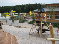 Die Spielhütte; hinten: Das Freibad Hirschau